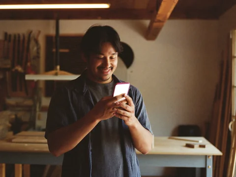 Ad creative — craftsman checks his phone, pleased